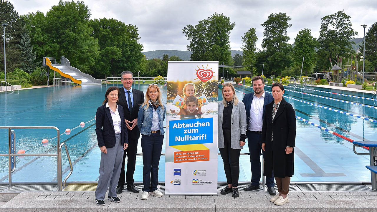 Sponsoring-Sommerferienaktion 2025 im Jenaer Ostbad: vl Beatrice Weinberger (Pressesprecherin Carl Zeiss AG), Andreas Deiß (Vorstand WG Carl Zeiss eG), Ines Eckert (Leiterin Unternehmenskommunikation Stadtwerke Jena GmbH), Susan Zetzmann (Geschäftsführerin Jenaer Bäder und Freizeit GmbH), Johannes Schleußner, Vorsitzender des Bäderbeirats und Dezernent für Bildung, Jugend, Kultur und Sport und Simone Uhlemann (Leiterin Marketing/Öffentlichkeitsarbeit WG Carl Zeiss eG). Foto: Jenaer Bäder; J. Scheere