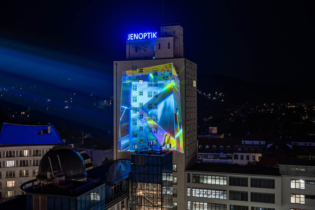 tangente digital art: Vom 17.–31. Oktober 2025 verwandelt ZEITGUISED das Jenoptik-Hochhaus in Jena mit „The Abbe Number“ in ein leuchtendes Kunstwerk aus Licht und Glas. Vom 17.–31. Oktober 2025 verwandelt ZEITGUISED das Jenoptik-Hochhaus in Jena mit „The Abbe Number“ in ein leuchtendes Kunstwerk aus Licht und Glas. Foto: Frank Liebold, Jenafotografx